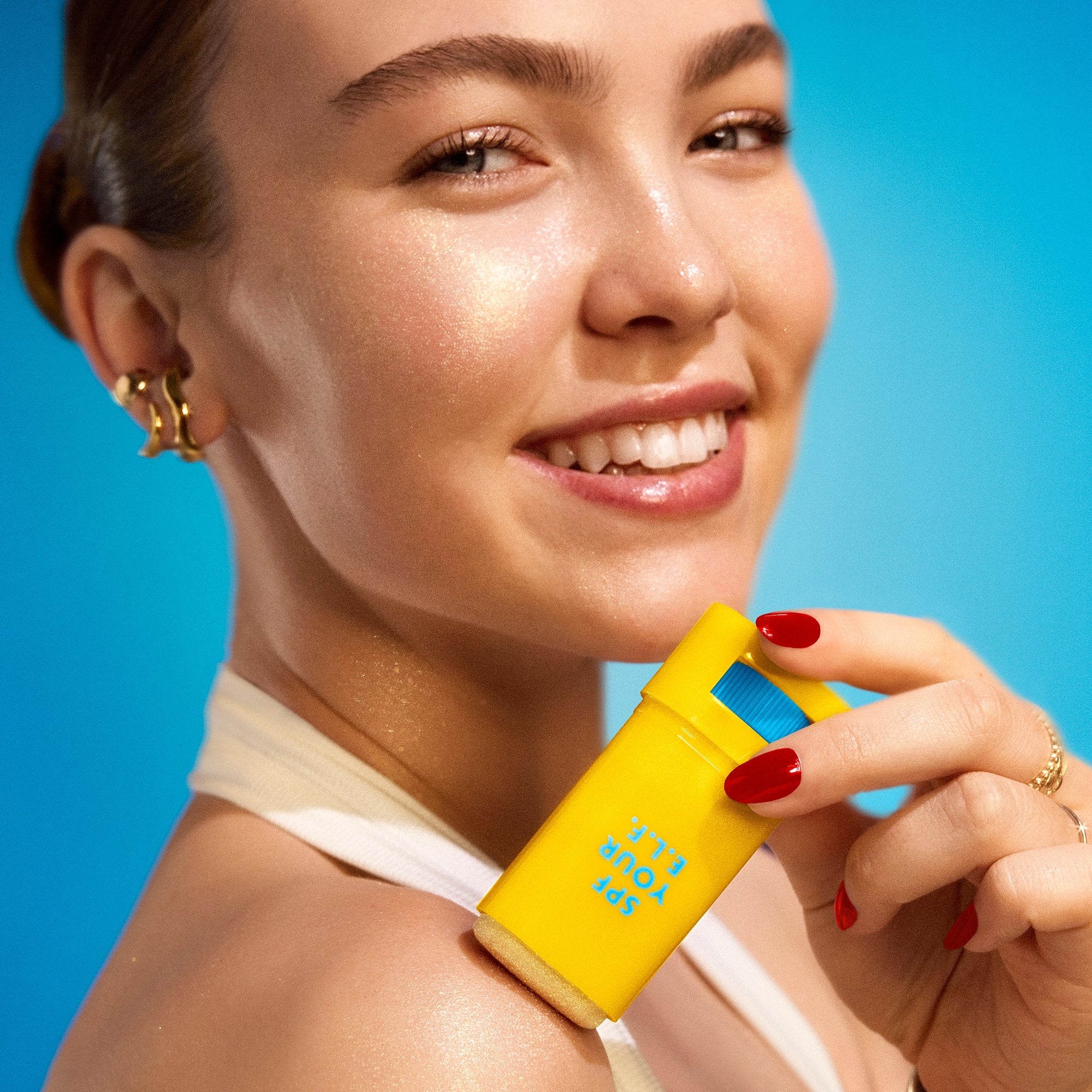 Close-up of a woman applying Invisi-Stick Glitz SPF 50 broad-spectrum sunscreen