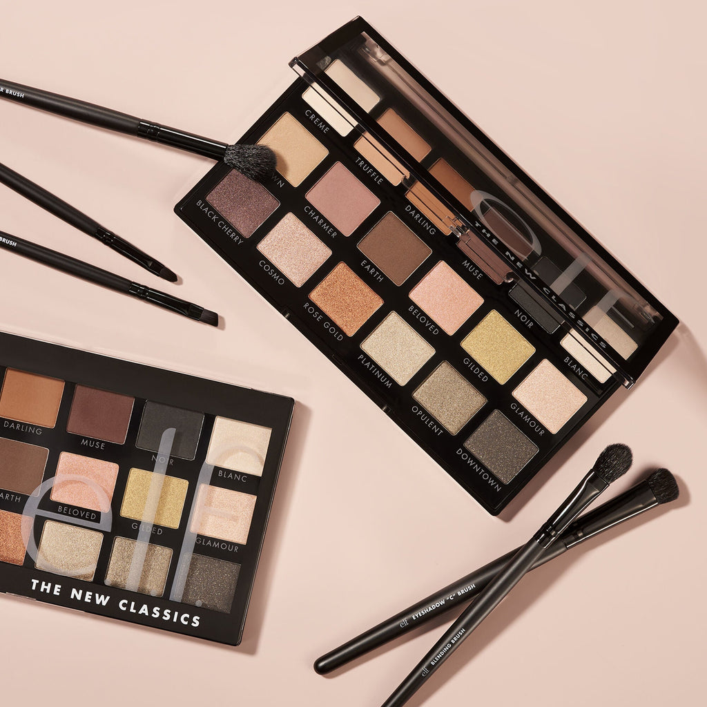 Makeup palettes with brushes on a beige background