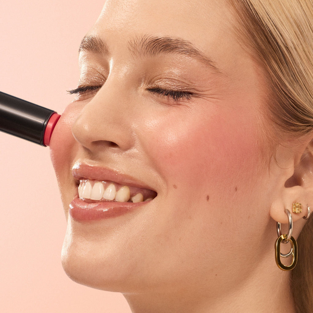Close-up of a woman applying Soft Glam Cream Blush