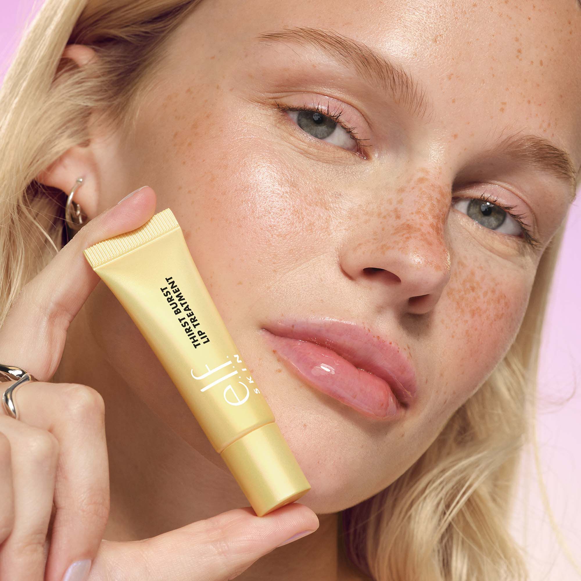 Woman Wearing and Holding Thirst Burst Clear Pomelo Lip Treatment