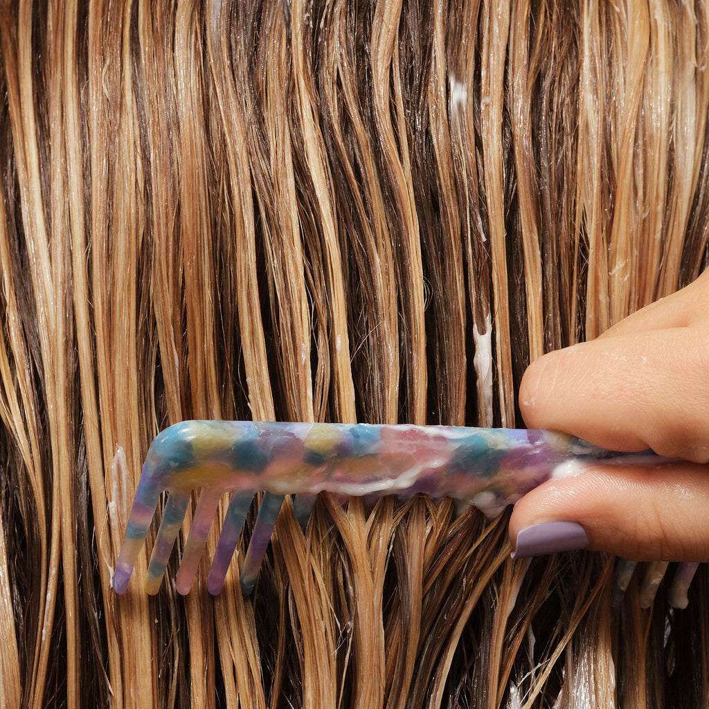 Person combing their hair after applying Never Thirsty conditioner