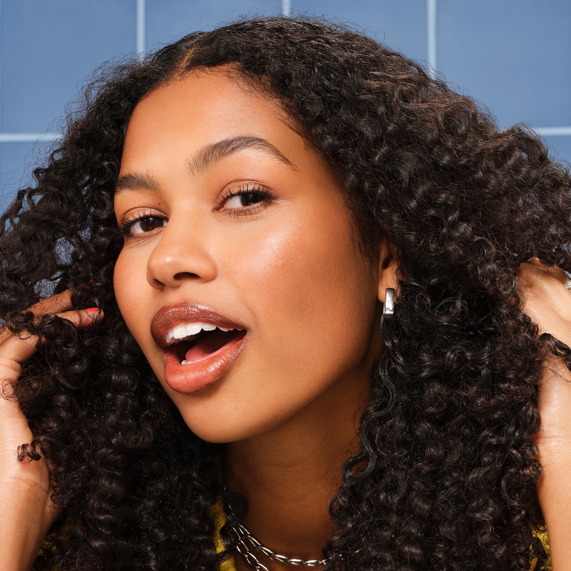 Woman with coily hair after using lightweight Never Thirsty Moisturizing Shampoo and Conditioner