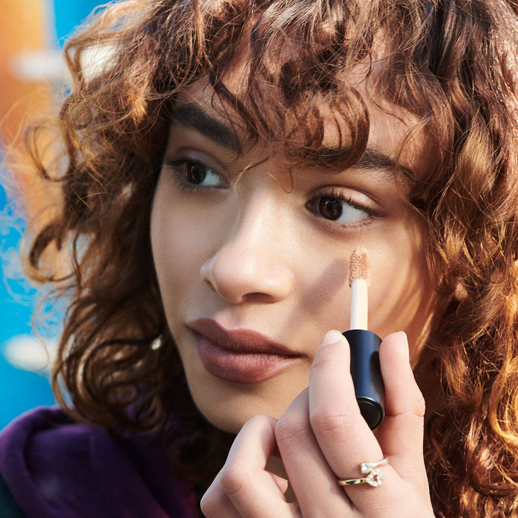 Woman Applying 16 HR Camo Concealer in Her Under Eye Area