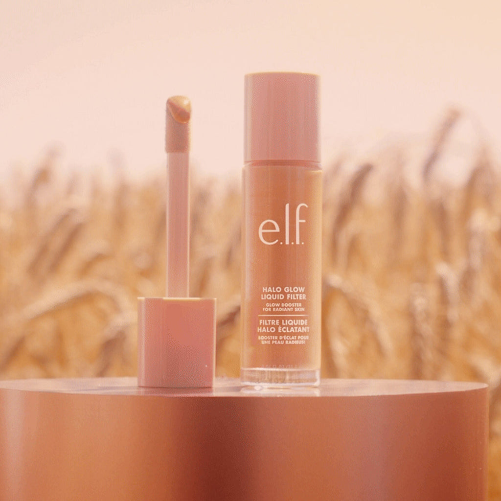 e.l.f. Halo Glow Liquid Filter with applicator on a wooden surface with a blurred natural background